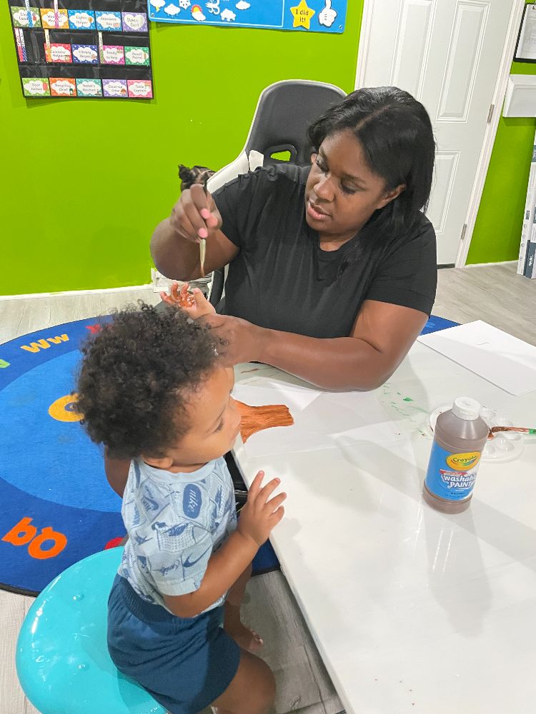 teacher painting preschoolers hands